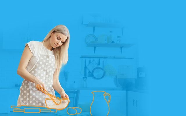 Woman wearing an apron with drawings of kitchen utensils and baking ingredients